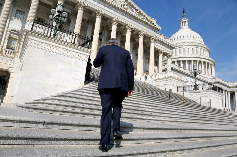A member of the U.S. House of Representatives talks on the phone as he arrives for a vote at the U.S. Capitol in Washington October 5, 2013.