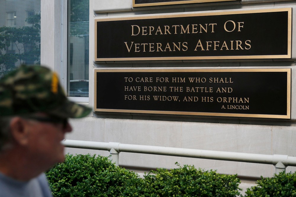 The sign in the front of the headquarters building at the Department of Veteran Affairs is seen as a man walks past in Washington