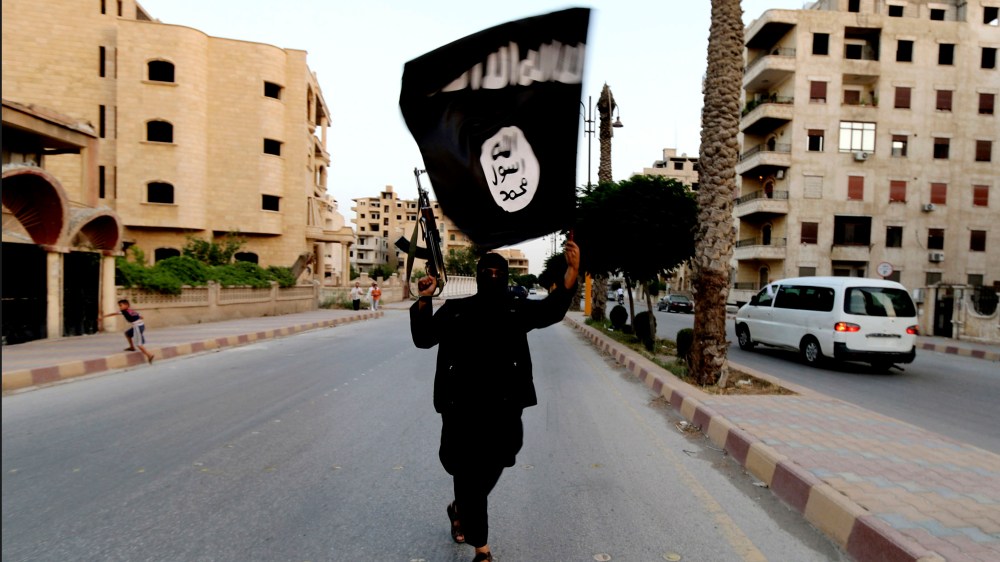 A member loyal to the Islamic State in Iraq and the Levant (ISIL) waves an ISIL flag in Raqqa June 29, 2014. (Photo by Reuters)