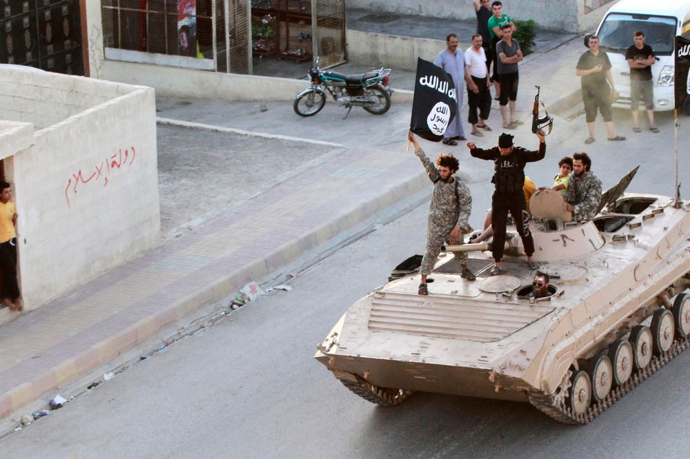 Militant Islamist fighters take part in a military parade along the streets of northern Raqqa province