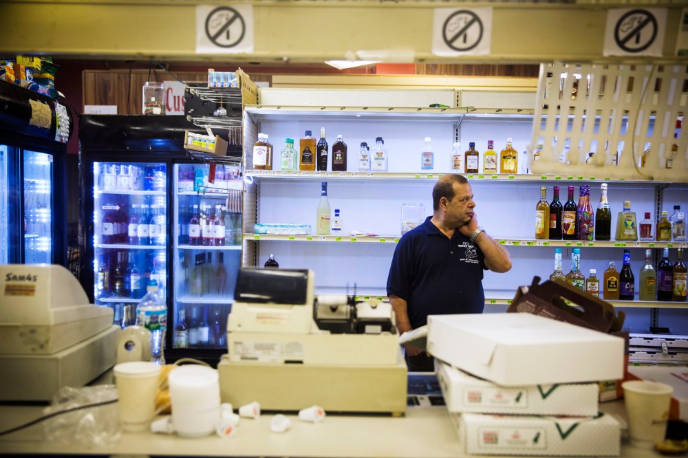 Sam's Meat Market & More employee Steve Sumad rubs his neck as he surveys damage caused by looters the night before in Ferguson, Missouri, August 16, 2014.