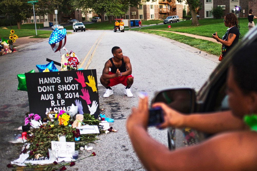 A nearby resident puts his hands together in prayer at a makeshift memorial near the site where unarmed teen Michael Brown was killed in Ferguson, Missouri, Aug. 22, 2014.