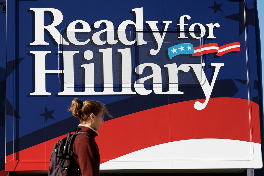 A woman walks by a bus supporting former U.S. Secretary of State Hillary Clinton at the location for Senator Tom Harkin's 37th Steak Fry in Indianola