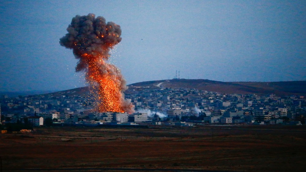 Smoke rises over Syrian town of Kobani after an airstrike, as seen from the Mursitpinar border crossing on the Turkish-Syrian border in the southeastern town of Suruc, Turkey on Oct. 18, 2014. (Photo by Kai Pfaffenbach/Reuters)