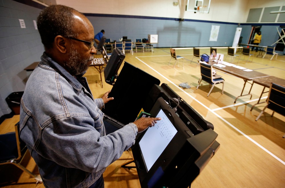 Poll worker Willie Stafford Jr. programs a voting terminal before the start of the voting at the Grove Presbyterian Church in Charlotte, NC, Nov. 4, 2014. (Photo by Chris Keane/Reuters)