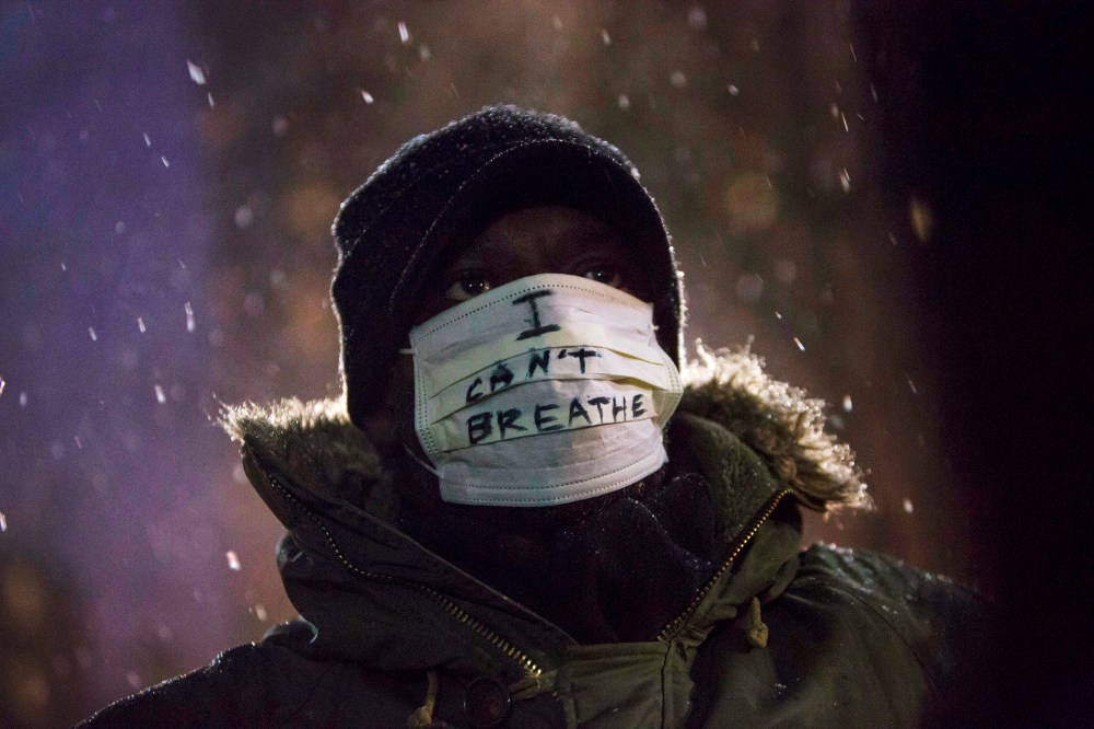 A man stands in falling snow following a news conference where members of Justice League NYC presented a list of demands at City Hall in New York, N.Y. on Dec. 10, 2014. (Photo by Andrew Kelly/Reuters)