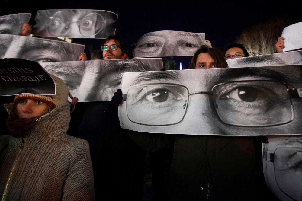 People hold up posters with the eyes of Charlie Hebdo Editor Stephane Charbonnier (front) and Jean Cabut (back L) during a vigil to pay tribute to the victims of the Paris shooting, in the New York City Jan. 7, 2015. (Photo by Carlo Allegri/Reuters)
