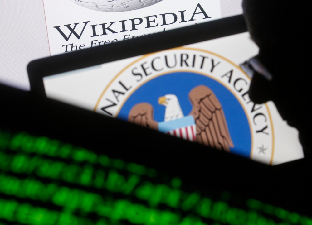 A man is seen near cyber code and the US National Security Agency logo in this photo illustration taken in Sarajevo March 11, 2015. (Photo by Dado Ruvic/Reuters)