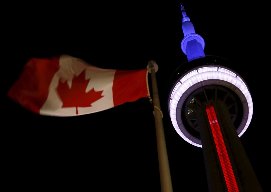 The landmark CN Tower is lit blue, white and red in the colors of the French flag following Paris attacks, in Toronto, Nov. 13, 2015. (Photo by Chris Helgren/Reuters)