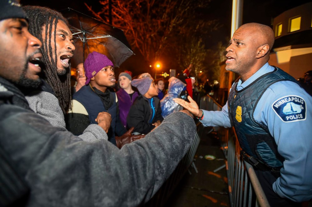 A police officer talks with demonstrators in front of a north Minneapolis police precinct during a protest in response of Sunday's shooting death of Jamar Clark by police officers in Minneapolis, Minn., Nov. 18, 2015. (Photo by Craig Lassig/Reuters)