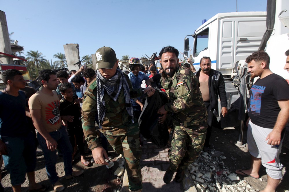 Members of the Hashid Shaabi Shi'ite militia carry the body of a victim of a bomb attack at a checkpoint in the city of Hilla, south of Baghdad, March 6, 2016. (Photo by Alaa Al-Marjani/Reuters)