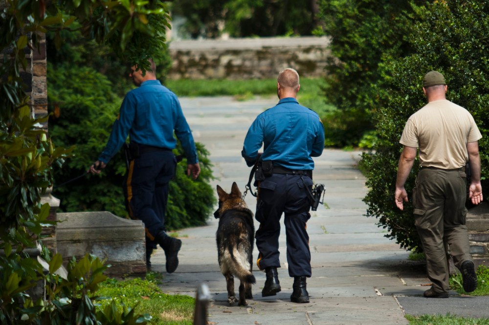 New Jersey police officers patrol on foot with dogs inside the campus of Princeton University in New Jersey June 11, 2013. (Photo by Eduardo Munoz/Reuters)