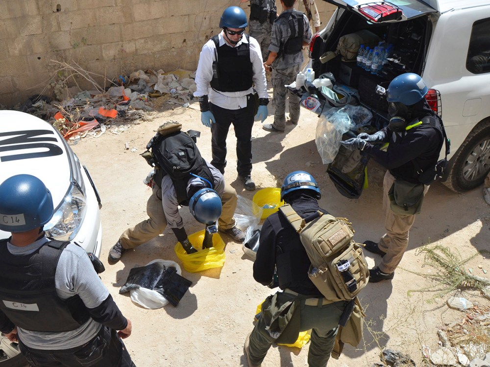 U.N. chemical weapons experts prepare before collecting samples from one of the sites of an alleged chemical weapons attack in Damascus' suburb of Zamalka August 29, 2013.