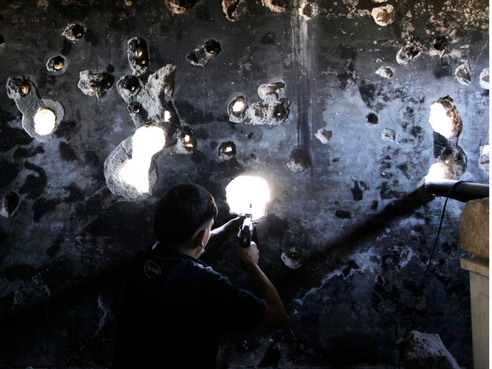 A Free Syrian Army fighter takes up a shooting position in Ogiwl