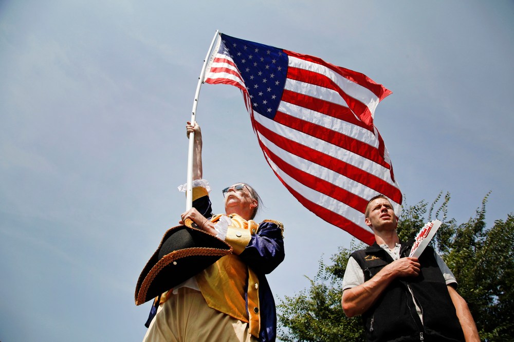People stand for the national anthem at a Tea Party Patriots rally on the west lawn of the U.S. Capitol, Sept. 10, 2013.