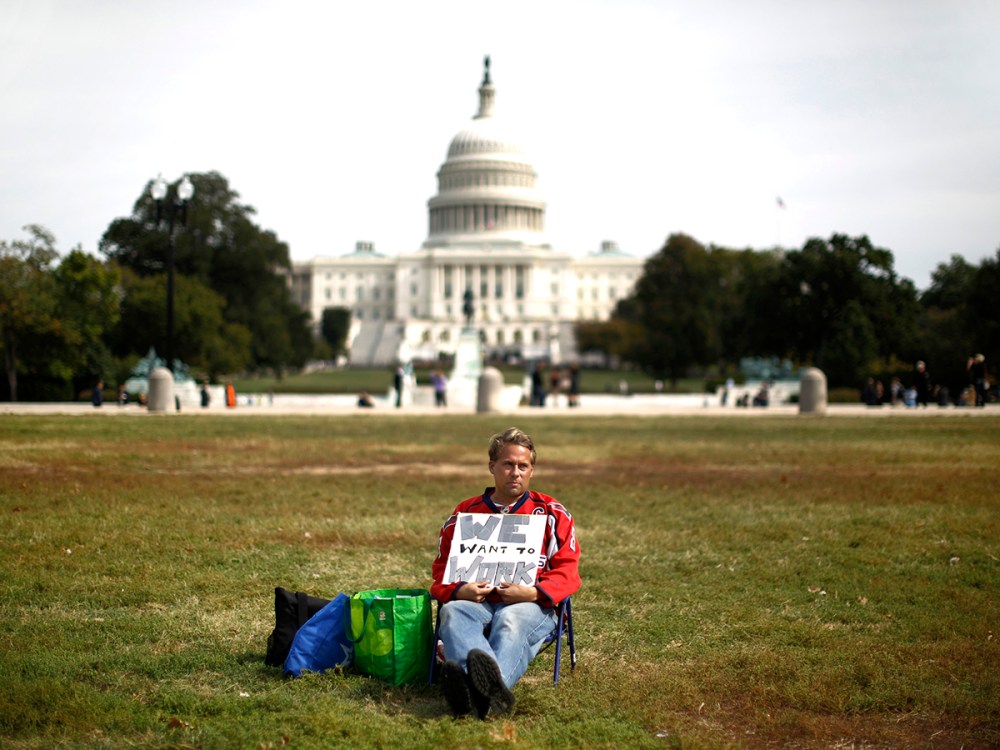 Furloughed Americorps employee Jeffrey Wismer sits alone on the Washington Mall October 8, 2013, as he calls on congress to end the government shut down.