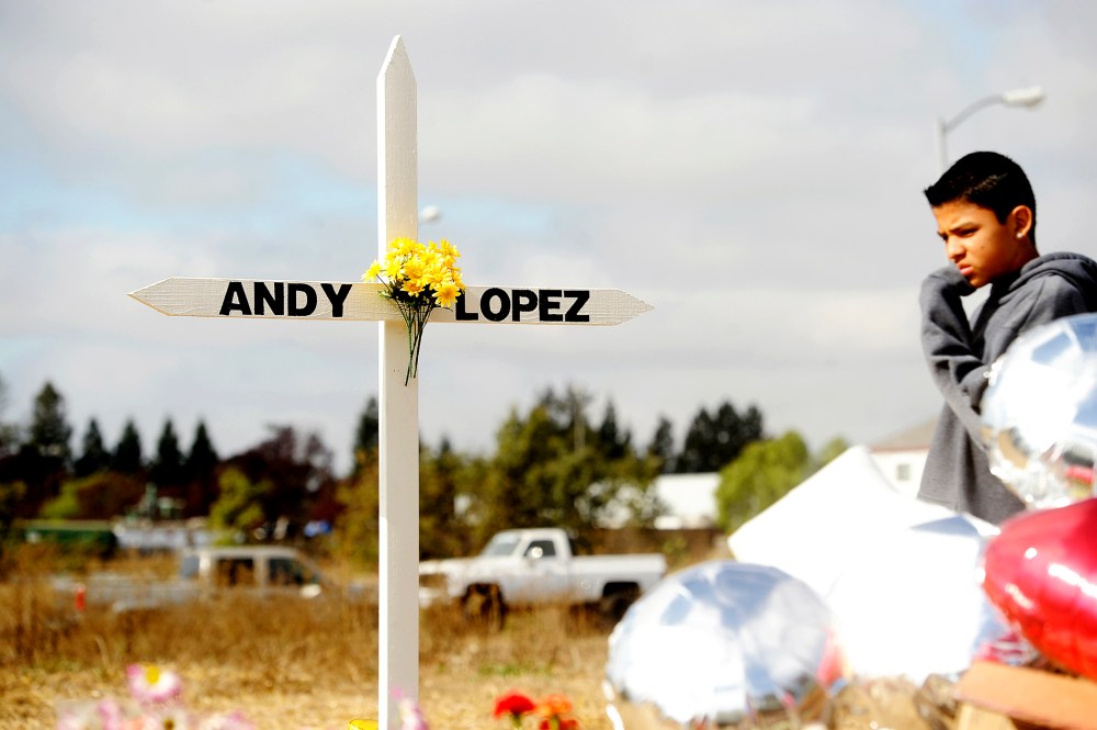 A boy passes a memorial marking the location where sheriff's deputies shot and killed 13-year-old Andy Lopez Cruz in Santa Rosa, Ca., October 27, 2013.
