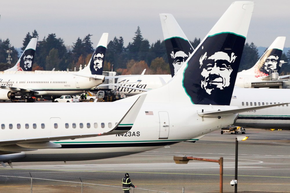 A ground crew member walks near Alaska Airlines planes parked at Seattle-Tacoma International Airport in SeaTac, Wash., Oct., 30, 2013. (Photo by Jason Redmond/Reuters)