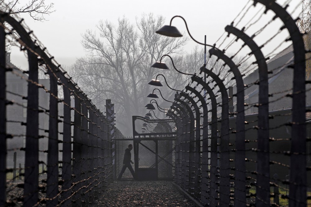 A visitor walks between electric barbed-wired fences at the Auschwitz-Birkenau memorial and former concentration camp Nov. 18, 2013. (Photo by Kacper Pempel/Reuters)