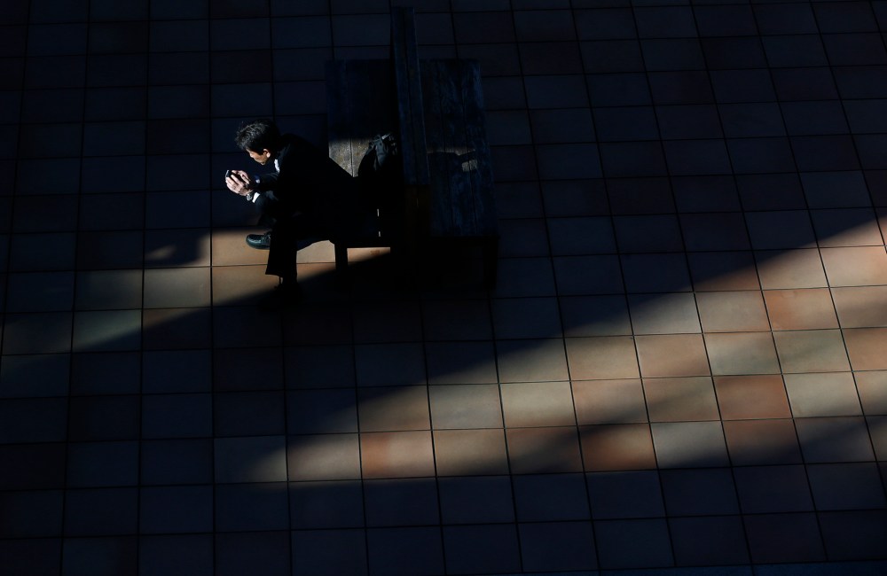 A man uses a smartphone on a street in Tokyo