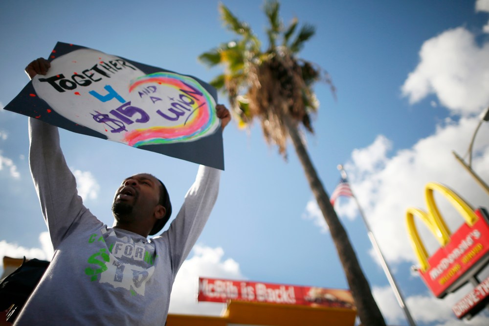 Joe Ben Johnson III holds a sign outside McDonald's in Los Angeles, Calif. on Dec. December 5, 2013.