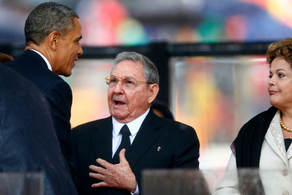 Barack Obama greets Cuban President Raul Castro before giving his speech, as Brazil's President Dilma Rousseff looks on, at the memorial service for Nelson Mandela, Dec. 10, 2013.