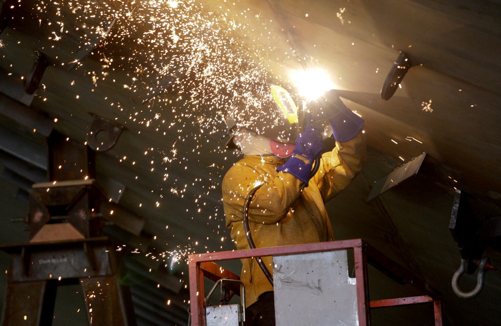 Vigor Industrial employee welds metal on a ferry being built for Washington State Ferries at the company's Harbor Island centre in Seattle