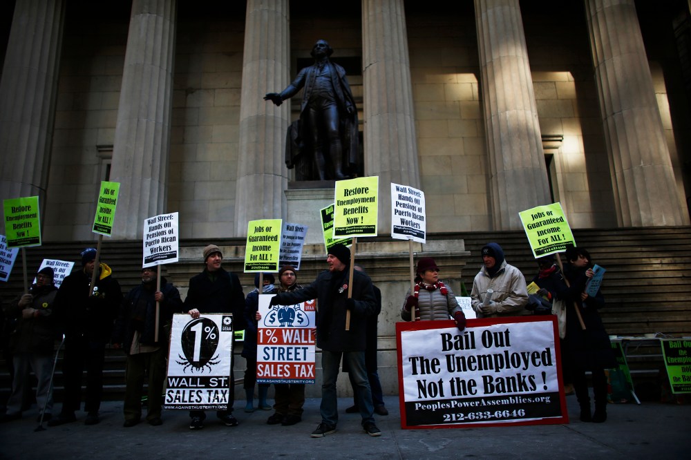 Members of Occupy Wall Street and People Power Assembly take part in a protest demanding restoration of extended unemployment benefits next to the New York Stock Exchange in New York