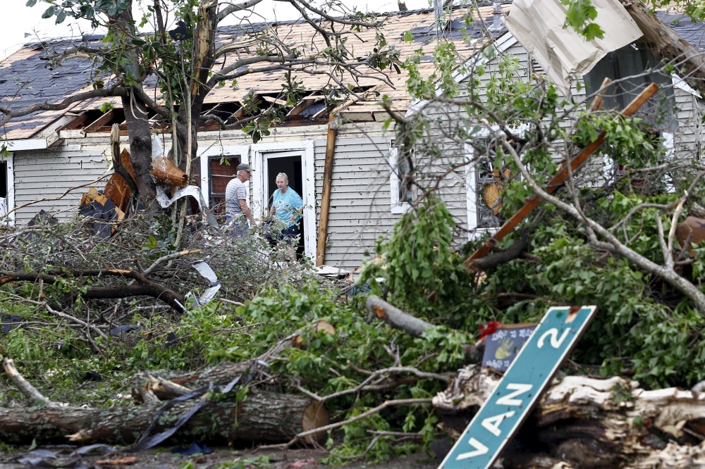 A man and woman talk at the entrance of a house that was destroyed after a tornado swept through the area the previous night in Van, Texas on May 11, 2015. (Photo by Mike Stone/Reuters)
