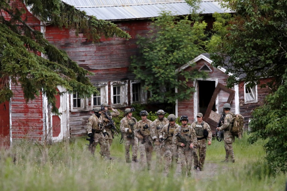 Police officers search a property near the Clinton Correctional Facility in Dannemora, New York, June 8, 2015. (Photo by Chris Wattie/Reuters)