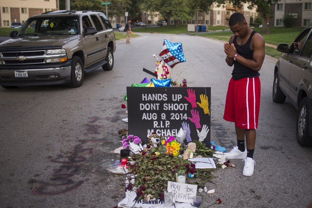 Local resident Ken Kendricks Jr. puts his hands together in prayer at a makeshift memorial at the site along Canfield Road where unarmed teen Michael Brown was shot dead in Ferguson, Mo., Aug. 22, 2014. (Photo by Adrees Latif/Reuters)