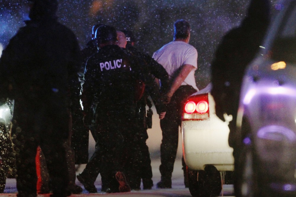 The handcuffed suspected gunman at the Planned Parenthood clinic is moved to a police vehicle in Colorado Springs, Colo., Nov. 27, 2015. (Photo by Rick Wilking/Reuters)