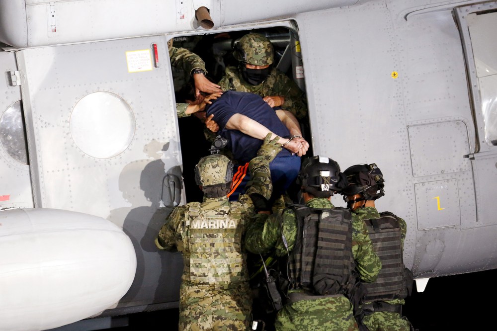 Soldiers escort drug lord Joaquin "El Chapo" Guzman into a helicopter during a presentation to the media in Mexico City, Jan. 8, 2016. (Photo by Tomas Bravo/Reuters)
