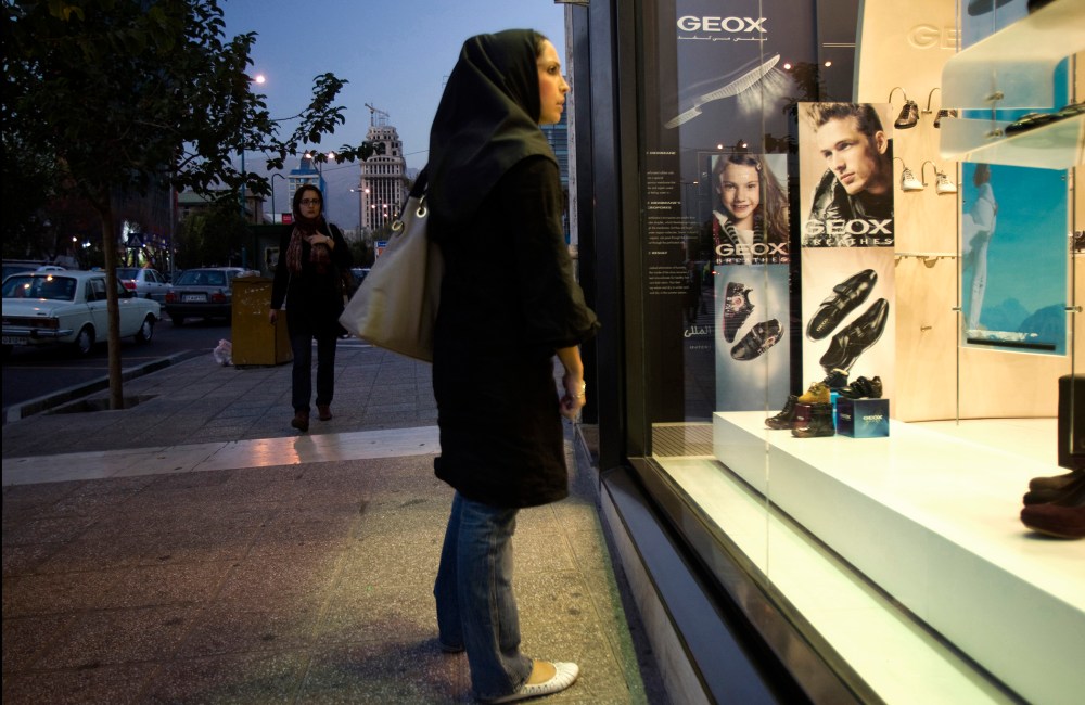 An Iranian woman looks in the window of a Geox store in northern Tehran