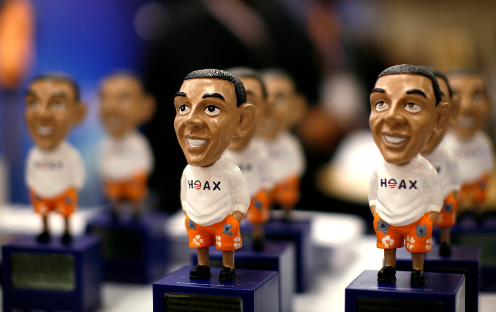 Figures of President Obama with the word "Hoax" are on display at the CPAC in Washington
