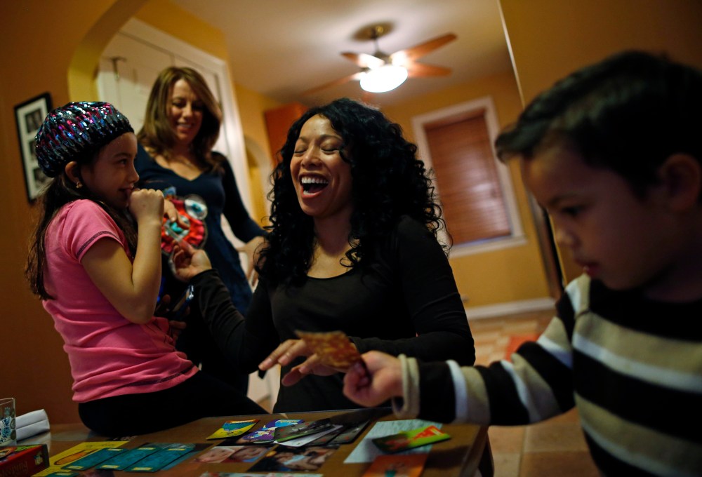 Mercedes Santos shares a laugh with her partner, Theresa Volpe, while playing cards with their kids at home in Chicago, Illinois, December 22, 2012.