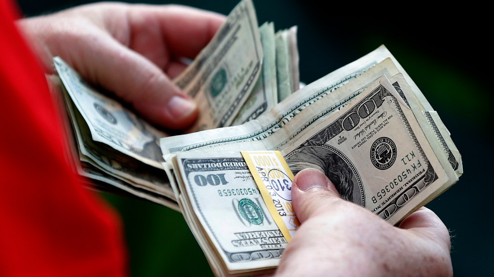 A man counts his money. (Photo by Phil Noble/Reuters)