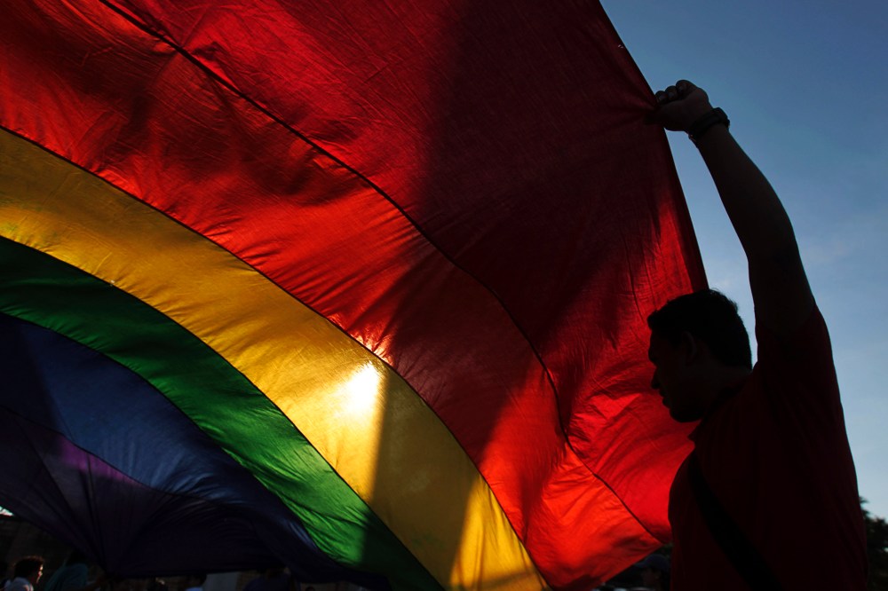 A gay rights activist holds a rainbow flag during a rally to mark the International Day Against Homophobia in Managua