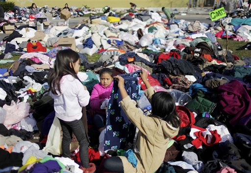 Jasmine Vargas, center, looks through donated clothes at an aid station in the Midland Beach section of Staten Island, New York, Monday, Nov. 5, 2012.  The massive storm that started out as Hurricane Sandy slammed into the East Coast and morphed into a...