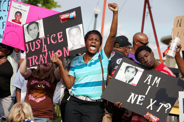 Protestors Lakesha Hall and her son Calvin Simms cheering and holding up signs.