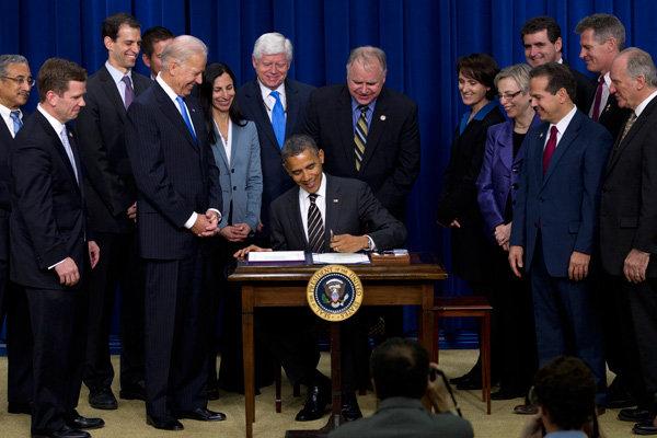 President Obama signs the STOCK Act in to law on Wednesday in Washington. From left to right, Rep. Bobby Scott, Rep. Robert Dold, Robert Weissman, Rep. Sean Duffy, Vice President Biden, Melanie Sloan, Rep. John Larson, Rep. Tim Walz, Katherine McFate,...
