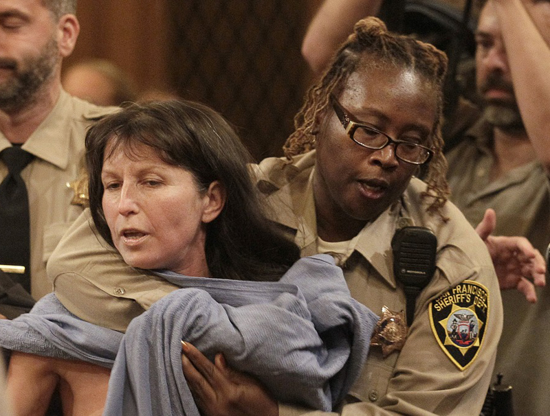 Protester Gypsy Taub is covered up by a San Francisco Sheriff after taking off her clothes at a Board of Supervisors meeting at City Hall in San Francisco, Tuesday, Nov. 20. San Francisco lawmakers on Tuesday narrowly approved a proposal to ban public...