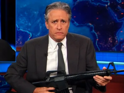 The Daily Show's Jon Stewart holding a plastic gun on Tuesday's show.