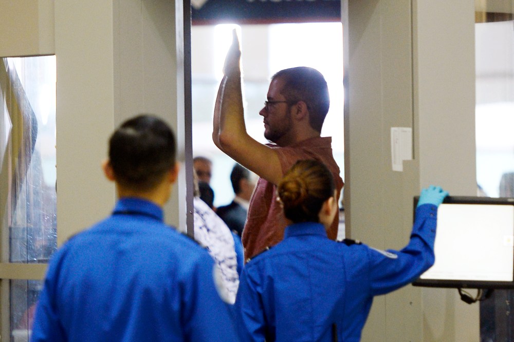 An airline passenger stands in a full-body scanner at Transportation Security Administration checkpoint at Los Angeles International Airport