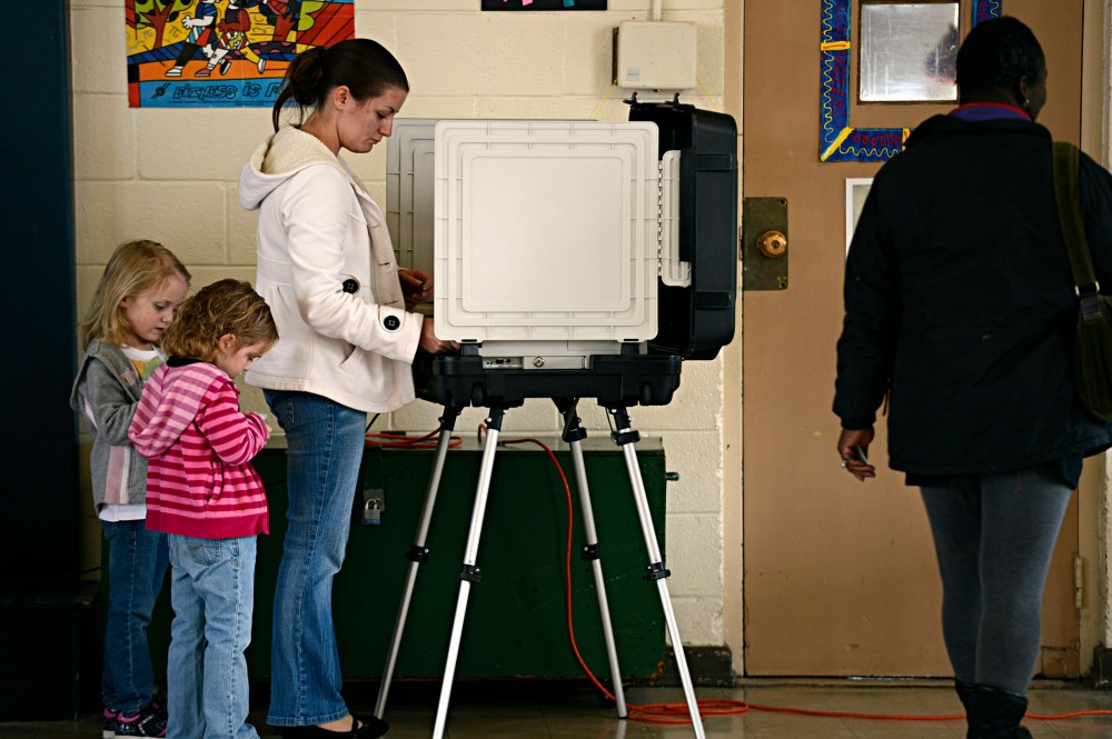Ashley Zorman votes while her daughters Erica Zorman, left, and Keira Zorman, look on at Little Creek Elementary School in Norfolk, Va.  on Tuesday, Nov.  6, 2012.