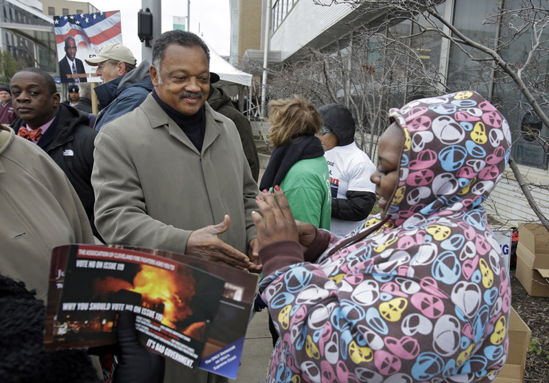 Rev. Jesse Jackson greets voters waiting in line at the Cuyahoga County Board of Elections in Cleveland on the final day of early voting Monday, Nov. 5. About 1.6 million people have already voted early in Ohio. (AP Photo/Mark Duncan)