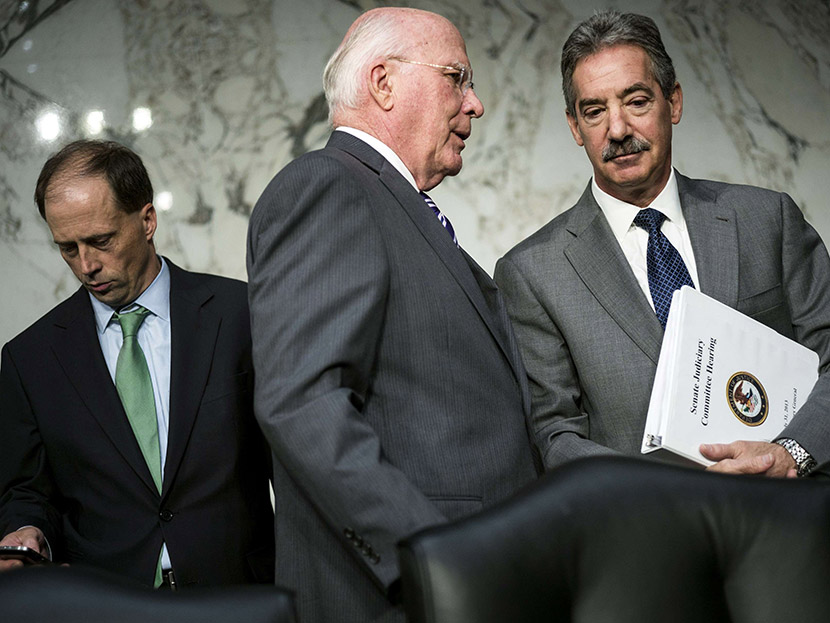 Committee chairman Sen. Patrick Leahy (C) speaks with Deputy Attorney General James Cole (R) after testimony from the first panel of witnesses during a hearing of the Senate Judiciary Committee on Capitol Hill July 31, 2013 in Washington, D.C. (Photo...