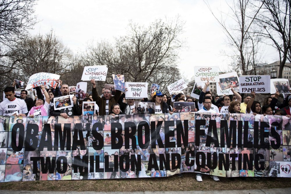 Activists hold signs and family photos in Lafayette Square outside the White House March 12, 2014 in Washington, D.C.