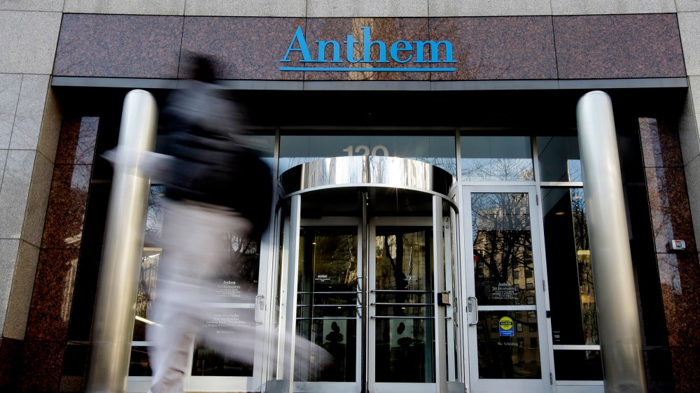 A pedestrian walks past the corporate headquarters of health insurer Anthem, formerly known as Wellpoint, on Dec. 3, 2014 in Indianapolis. (Photo by Darron Cummings/AP)