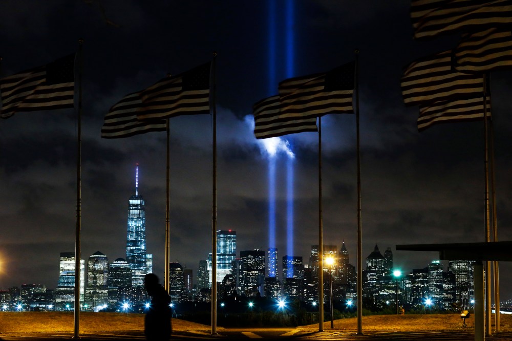 Man walks past as the Tribute in Light is illuminated on the skyline of lower Manhattan during events marking the 13th anniversary of the 9/11 attacks on the World Trade Center in New York